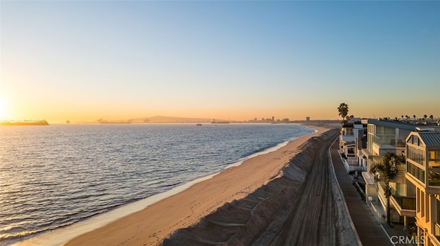 dock area featuring a water view and a beach view