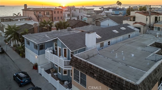 aerial view at dusk featuring a water view