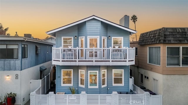 back house at dusk with a balcony