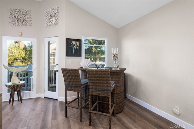 dining space with dark hardwood / wood-style flooring and high vaulted ceiling