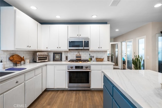 kitchen featuring hardwood / wood-style flooring, white cabinets, and appliances with stainless steel finishes