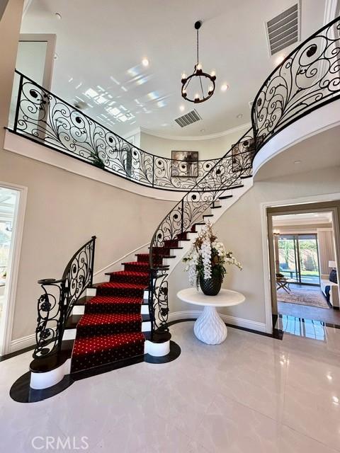 staircase featuring tile patterned floors and a high ceiling