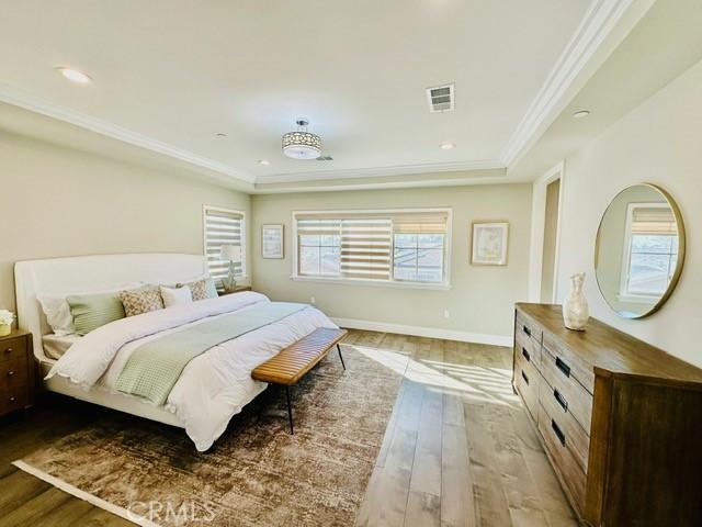 bedroom with ornamental molding and light hardwood / wood-style flooring