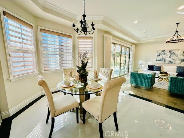 dining area featuring a notable chandelier, a healthy amount of sunlight, and crown molding