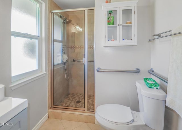 bathroom with tile patterned floors, a shower with door, vanity, and toilet