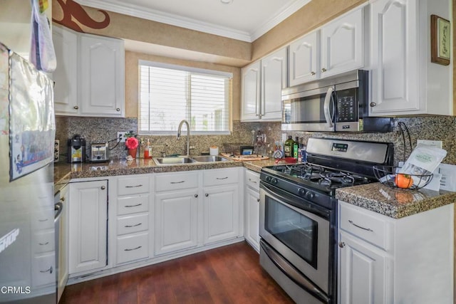 kitchen with white cabinets, appliances with stainless steel finishes, ornamental molding, and dark wood-type flooring