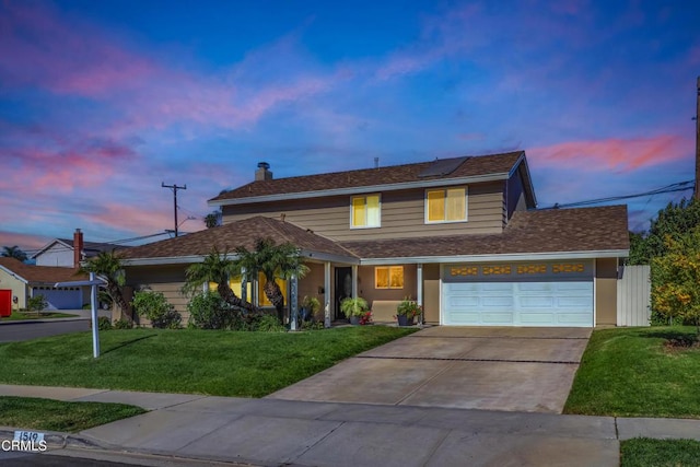 view of front property featuring solar panels, a garage, and a yard