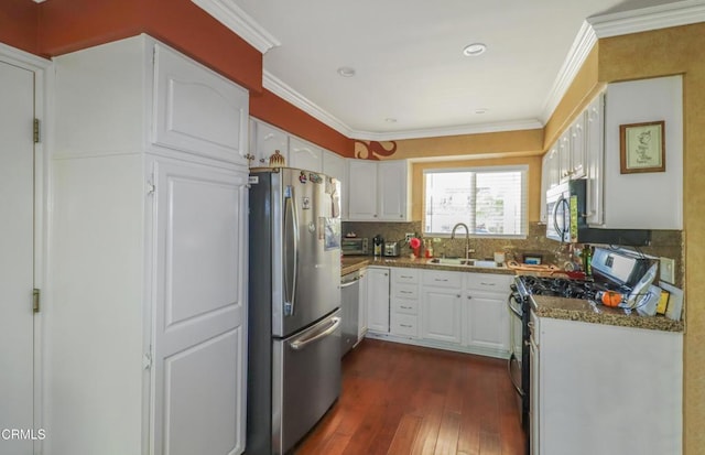 kitchen featuring white cabinetry, sink, dark hardwood / wood-style flooring, dark stone countertops, and appliances with stainless steel finishes