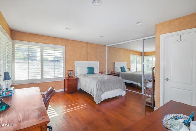 bedroom with multiple windows and hardwood / wood-style flooring