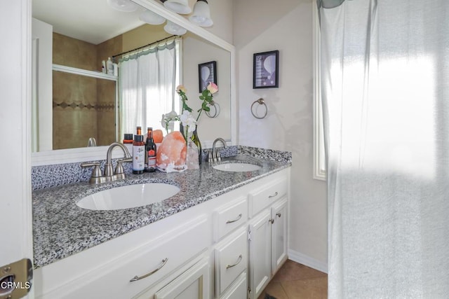 bathroom with tile patterned flooring, vanity, and walk in shower