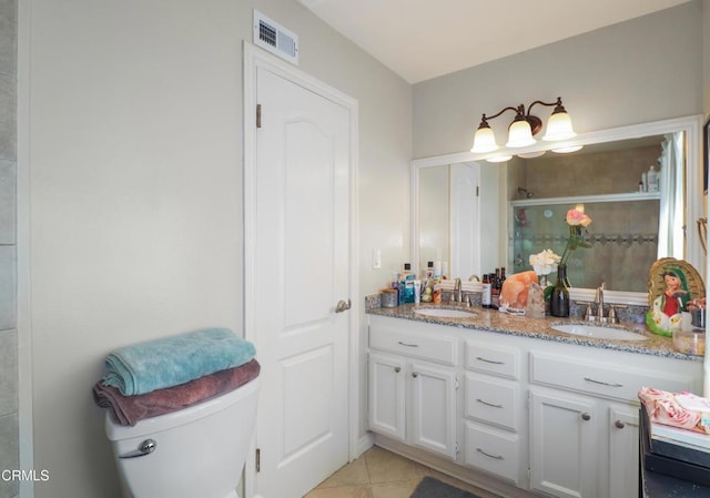 bathroom featuring toilet, tile patterned flooring, vanity, and walk in shower