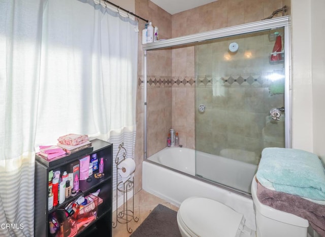 bathroom featuring tile patterned floors, combined bath / shower with glass door, and toilet