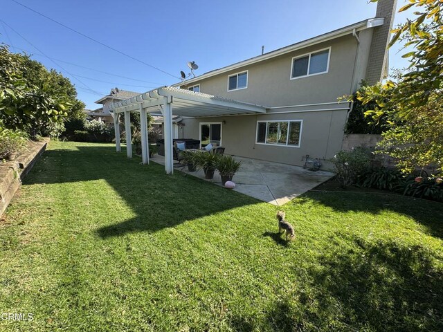 back of house featuring a pergola, a patio, stucco siding, a chimney, and a lawn