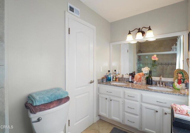 bathroom featuring tile patterned floors, visible vents, a sink, and a stall shower