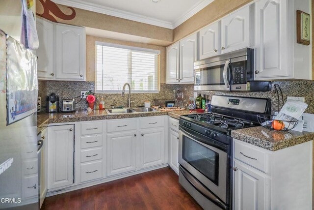 kitchen featuring white cabinets, stainless steel appliances, ornamental molding, and a sink