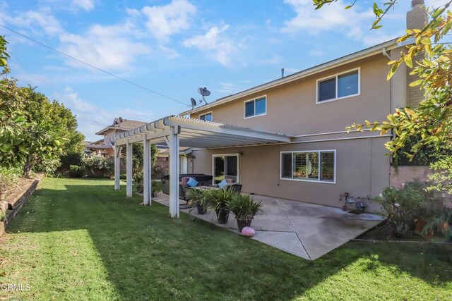 back of property with a lawn, a pergola, a patio area, and stucco siding