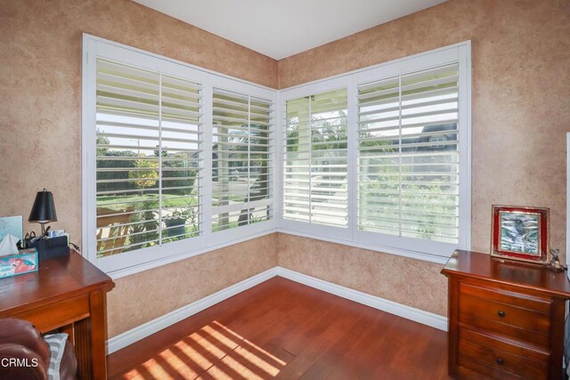 interior space with baseboards and wood finished floors