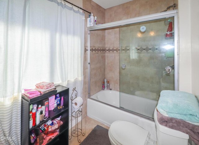 full bath featuring shower / bath combination with glass door, tile patterned flooring, and toilet