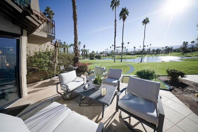 view of patio / terrace with a water view, an outdoor hangout area, and a balcony