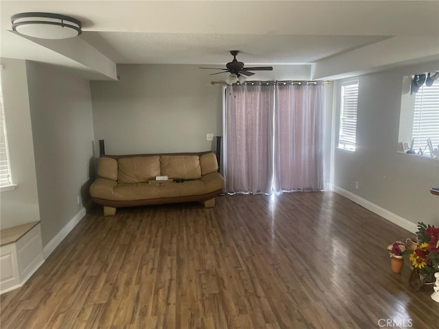 unfurnished living room featuring ceiling fan, dark hardwood / wood-style flooring, and a textured ceiling