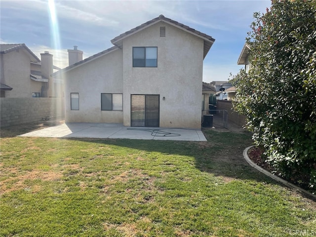 back of house with a lawn and a patio area