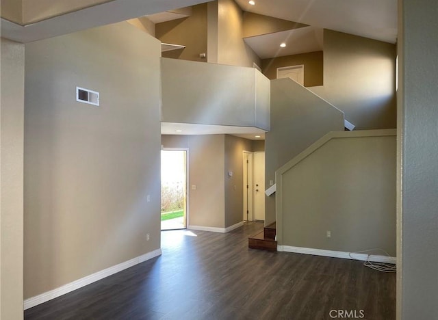 interior space with high vaulted ceiling and dark wood-type flooring