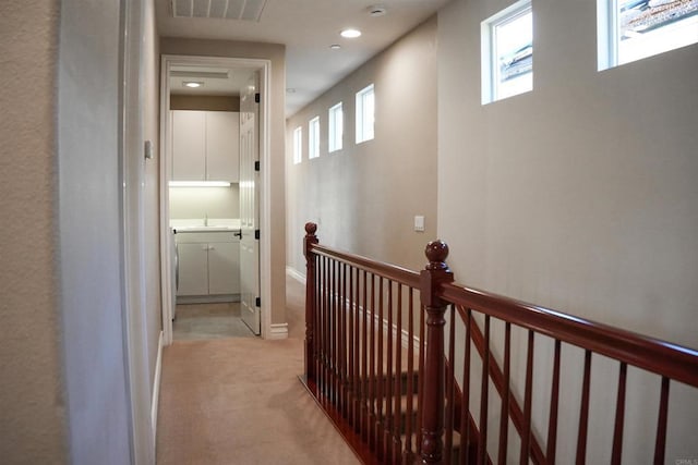 hallway with plenty of natural light and light carpet