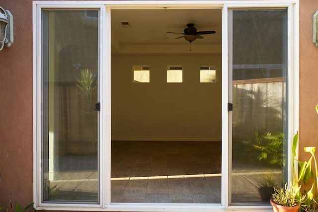 view of exterior entry featuring ceiling fan