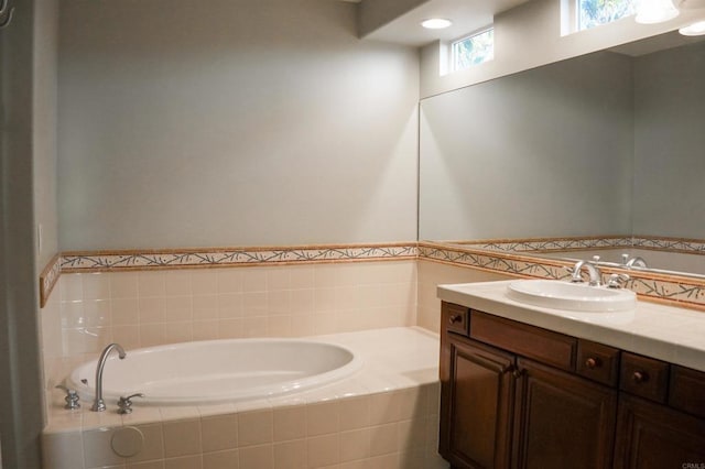 bathroom with tiled bath and vanity