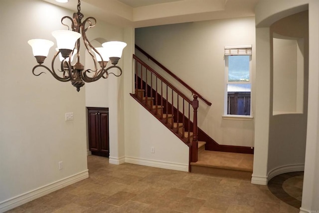 stairs with a chandelier