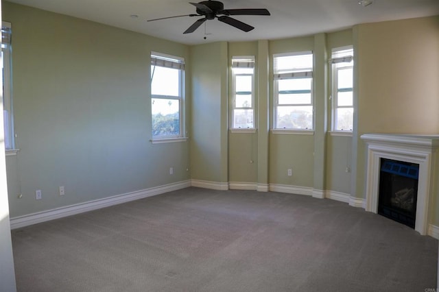 unfurnished living room featuring ceiling fan and carpet floors