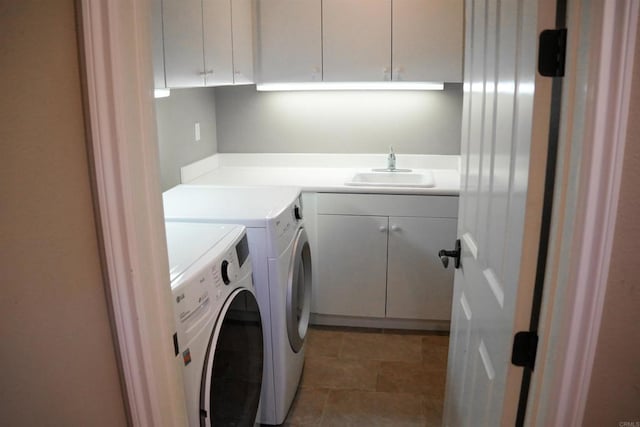 laundry area with washing machine and clothes dryer, sink, and cabinets