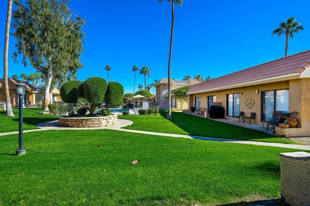 view of property's community featuring a yard and a swimming pool