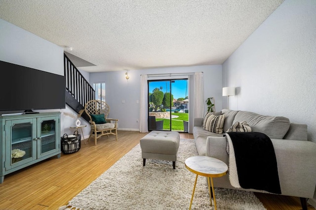 living room featuring light hardwood / wood-style floors and a textured ceiling