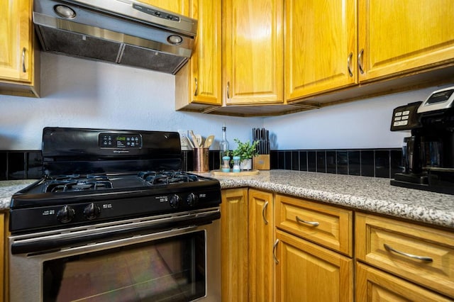 kitchen featuring light stone countertops, black range with gas cooktop, and extractor fan