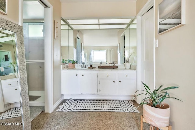 bathroom featuring vanity, walk in shower, and a wealth of natural light