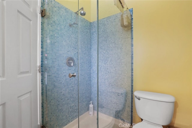 bathroom with toilet and an enclosed shower