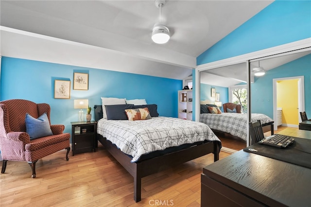 bedroom with ceiling fan, light hardwood / wood-style floors, a closet, and lofted ceiling