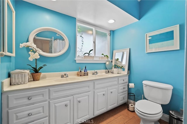 bathroom with hardwood / wood-style floors, toilet, and vanity