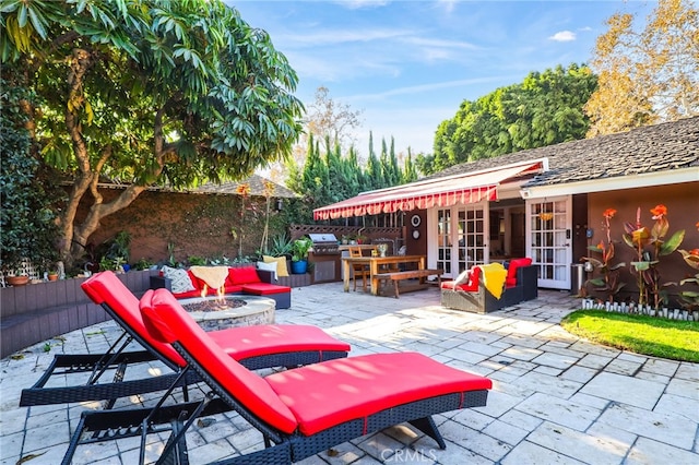 view of patio / terrace featuring exterior kitchen, grilling area, french doors, and an outdoor living space with a fire pit