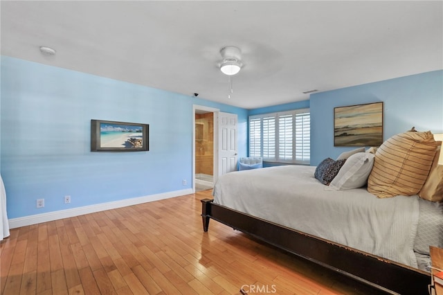 bedroom with ceiling fan, ensuite bathroom, and light wood-type flooring