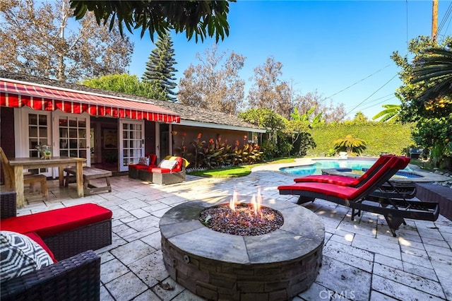 view of patio featuring french doors and an outdoor living space with a fire pit