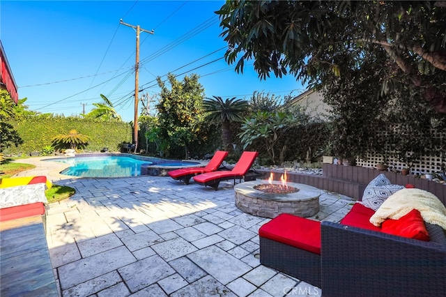 view of patio / terrace with an outdoor fire pit and a swimming pool with hot tub