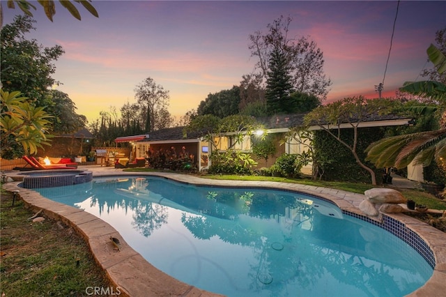 pool at dusk featuring a patio area