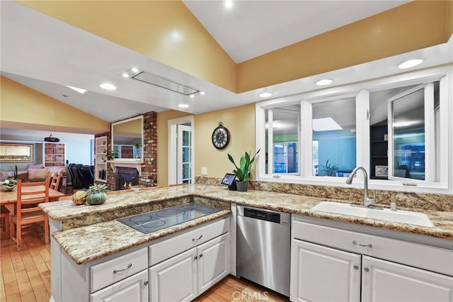 kitchen featuring kitchen peninsula, dishwasher, vaulted ceiling, white cabinets, and sink