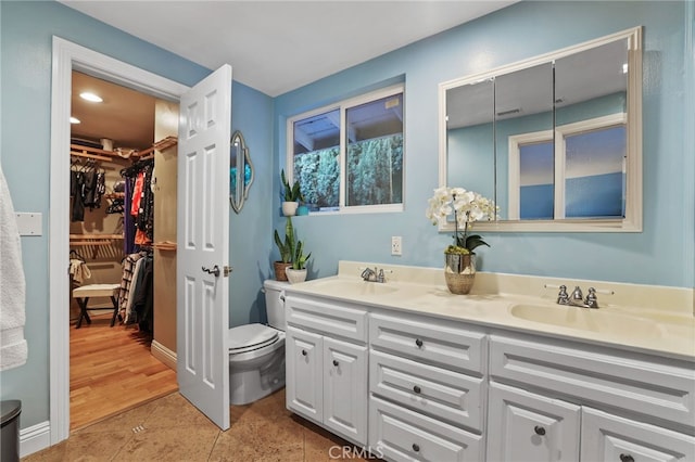 bathroom with toilet, tile patterned floors, and vanity