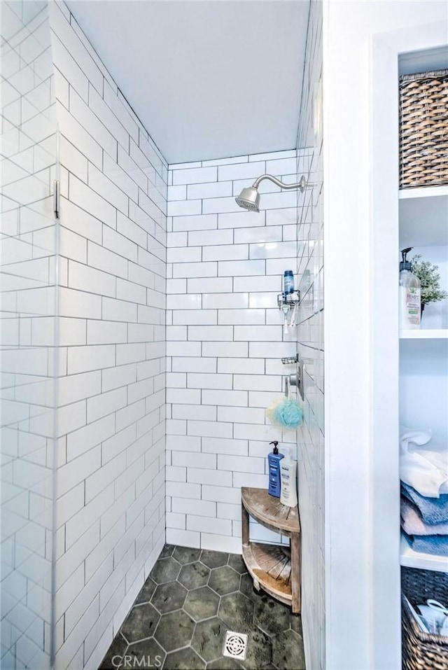 bathroom with tile patterned flooring and tiled shower