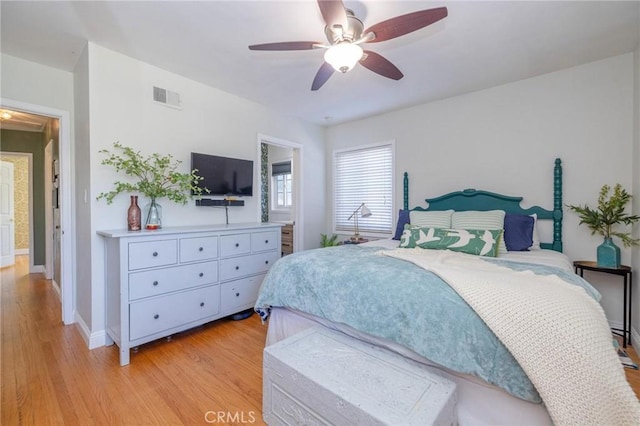 bedroom with light hardwood / wood-style floors, ceiling fan, and ensuite bathroom