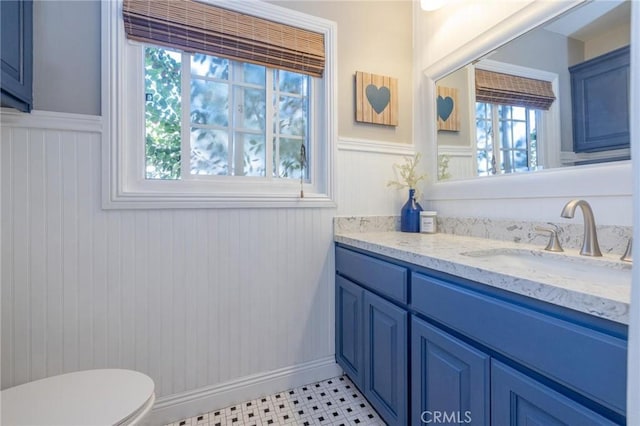 bathroom with tile patterned flooring, vanity, a healthy amount of sunlight, and toilet