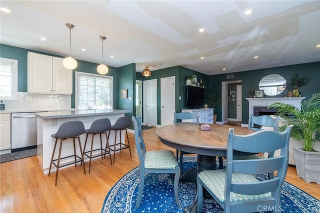 dining space featuring a fireplace and light hardwood / wood-style flooring